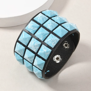 Detail of punk leather bracelet with blue marble pattern square rivets and silver snaps