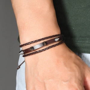 Gros plan du bracelet punk en cuir montrant les cordes tressées et les pointes en métal