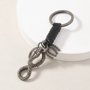 Vintage cobra snake keychain with braided leather wrap and horseshoe pendant detail