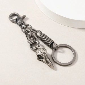 Detail of gothic raven skull keychain with vintage silver finish and alloy spring coil