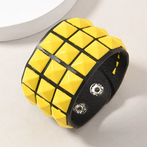Close-up of black punk leather bracelet with three rows of yellow pyramid studs