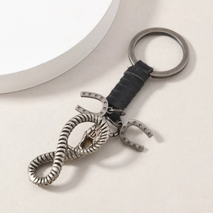 Vintage horseshoe keychain with leather wrap, ouroboros charm and star engraved pendants