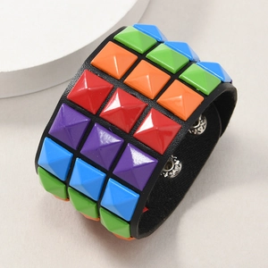Close-up of punk wide leather bracelet with colorful pyramid studs and metal snap buttons