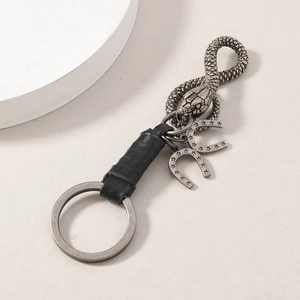 Macro shot of industrial metal snake keychain with leather wrap and horseshoe charms