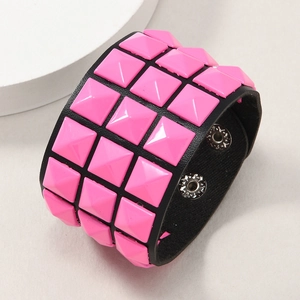 Close-up of black leather punk bracelet with three rows of pink pyramid rivets