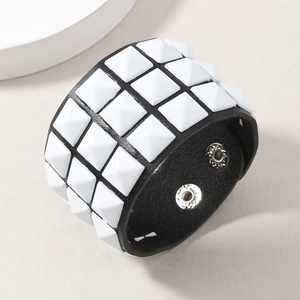 Detail of punk leather bracelet with four rows of white pyramid studs and snap buttons