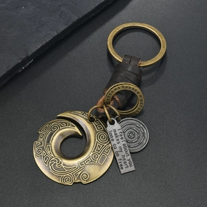 Close-up of bronze alloy pendant and woven leather cord on a vintage style keychain