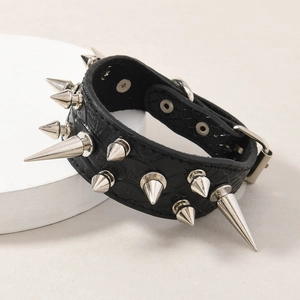 Muñequera punk de cuero negro con remaches plateados sobre soporte de exhibición blanco