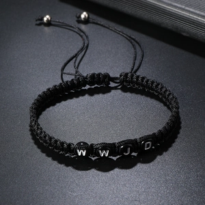 Macro shot of black woven cord bracelet with WWJD beads and adjustable slip knot closure