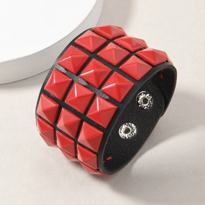 Close-up of punk black leather cuff bracelet with triple rows of red pyramid studs