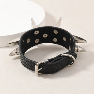 Pulsera punk de cuero negro con pinchos de metal plateado y textura piel de serpiente