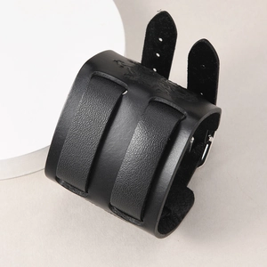 Primer plano de pulsera de cuero negro con relieve de dragón y hebillas metálicas dobles