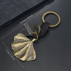 Macro view of retro keychain with bronze ginkgo leaf and leather detailing