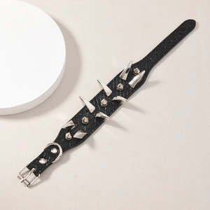 Detalle macro de la pulsera punk de cuero negro con textura grabada y puntas de metal
