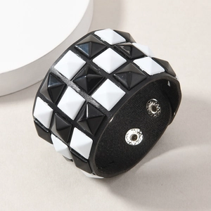 Detailed macro view of punk black and white pyramid studs on leather bracelet