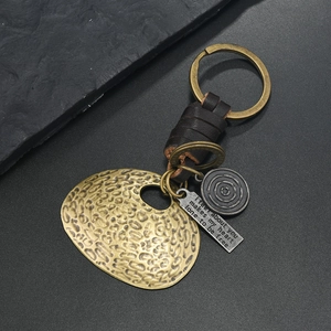 Detail view of vintage bronze key ring with leather strap and engraved metal tags