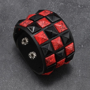 Detail of punk leather bracelet featuring red-black crackle studs and metal buttons