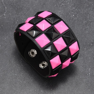 Detail of punk leather wristband featuring pink and black square pyramid rivets