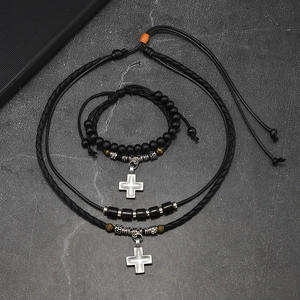 Set collana con ciondolo a croce retrò e bracciale di perline su marmo scuro