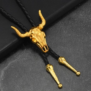 Détail du lacet bolo avec crâne de taureau doré gravé et cordon tressé noir