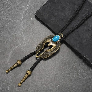 Close-up of vintage bronze eagle bolo tie with blue turquoise and black braided leather