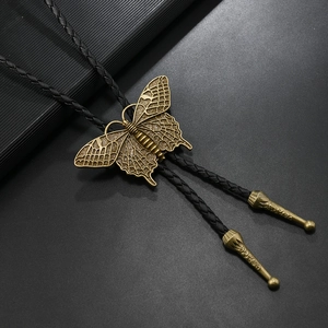 Macro shot of bronze butterfly bolo tie slider with success engraved metal tips