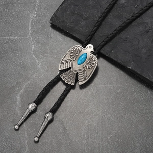 Detailed view of silver eagle Bolo tie with turquoise inlay and braided leather cord