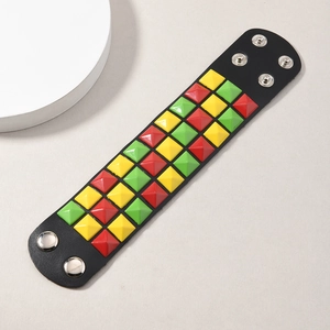 Macro detail of punk leather bracelet featuring three rows of colorful pyramid metal studs
