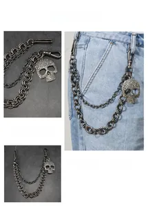 Detail view of double-layered punk metal pants chain with engraved skull charm on denim