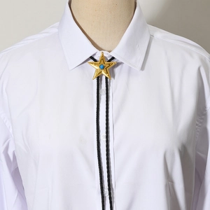 Cravate bolo étoile dorée avec pierre bleue et cordon noir sur une chemise blanche