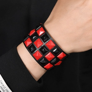 Punk style wide leather bracelet with three rows of red and black pyramid square studs