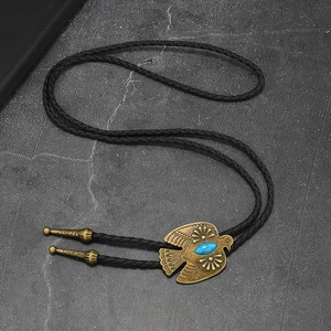 Detail of vintage eagle bolo tie with turquoise stone and ornate metal tips on black cord