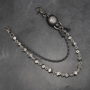 Detail of punk style dice charms and leather buckle on a double-layer metal wallet chain