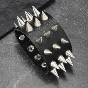 Macro shot of punk black leather wide bracelet with three rows of silver metal spikes