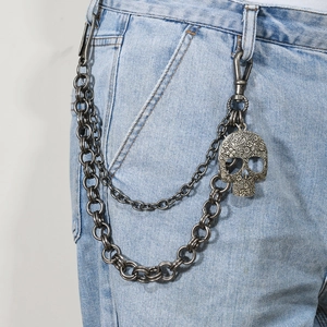 Double-layer punk pants chain with ornate metal skull pendant on denim jeans