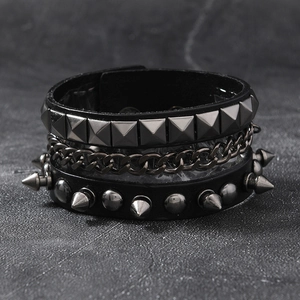 Detail of multilayer punk leather bracelet with metal studs, pyramid rivets and chain
