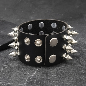 Detail of black leather punk bracelet with three rows of silver metal conical spikes