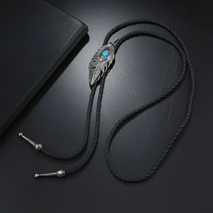 Macro view of vintage eagle feather bolo tie pendant with turquoise stone inlay