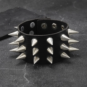 Punk black leather rivet bracelet with three rows of silver spikes on dark stone
