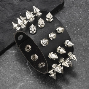 Detail view of gothic leather bracelet featuring four rows of sharp silver spikes and snap buttons