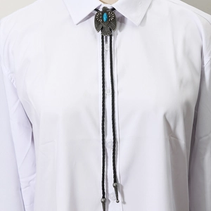 Close-up of vintage eagle bolo tie with blue turquoise on a white shirt