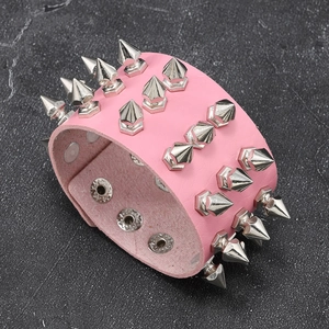 Detail of pink leather punk bracelet featuring three rows of sharp silver metal spikes