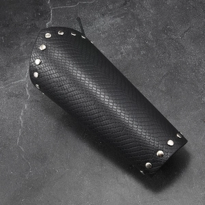 Detail view of black faux leather bracer with snake pattern and silver metal studs
