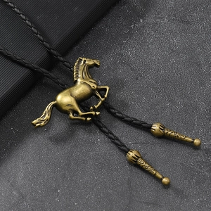 Detail einer Vintage-Bolo-Krawatte mit bronzefarbenem Pferdeanhänger an Lederkordel