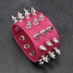 Detail of rose pink punk leather bracelet with three rows of silver metal spikes and snaps