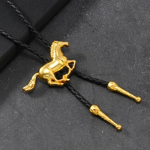 Makroaufnahme der goldenen Pferde-Bolo-Krawatte mit schwarzem Leder-Flechtseil