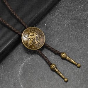 Dettaglio del cravattino bolo vintage con pentagramma in bronzo e cordino intrecciato