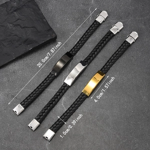 Detalle de pulseras de cuero trenzado con placas de metal pulido en oro, plata y negro mate