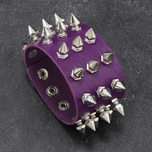 Detail of purple punk leather bracelet with three rows of silver metal spikes and snaps