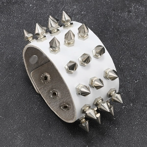 Detail view of white punk leather bracelet featuring four rows of sharp silver metal spikes